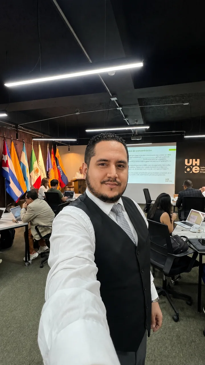 Ramón Maldonado durante una capacitación en vivo, con participantes trabajando en laptops detrás de él